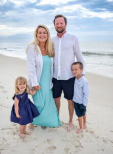 Dr. Mary Edwards Long in a white coat on Gulf Shores and Orange Beach beach with family edward and Elizabeth smiles and sunny day. Voted the best dentist on the island. Small Business of the Year award winner. Mother-daughter dentist duo. Cosmetic and general dentistry. Female dentist